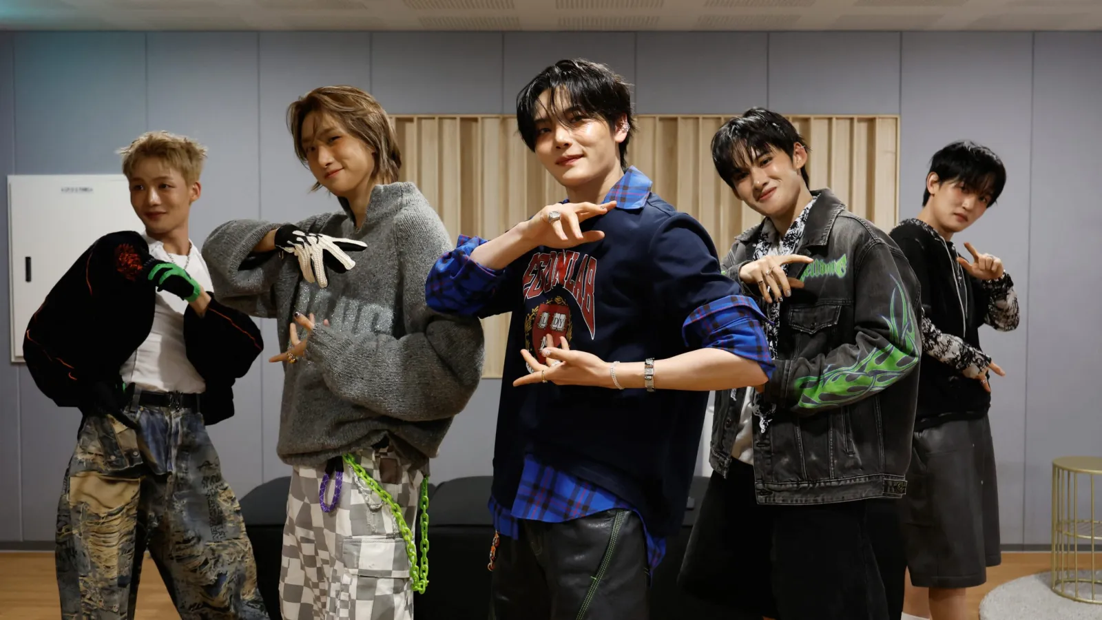 1. Four young men pose together for a photo in a well-lit room, smiling and standing close to each other.  